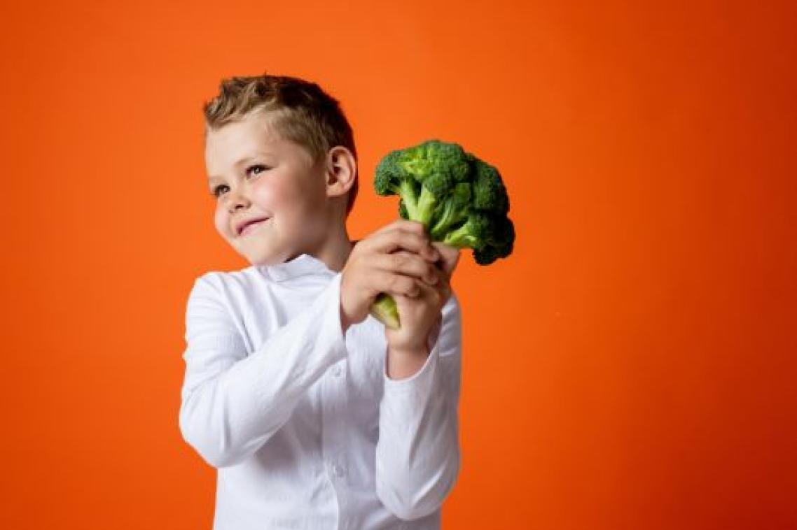 Boy holding head of broccoli