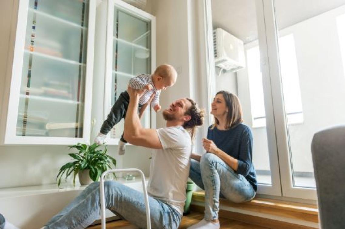 Young parents with dad holding toddler in air