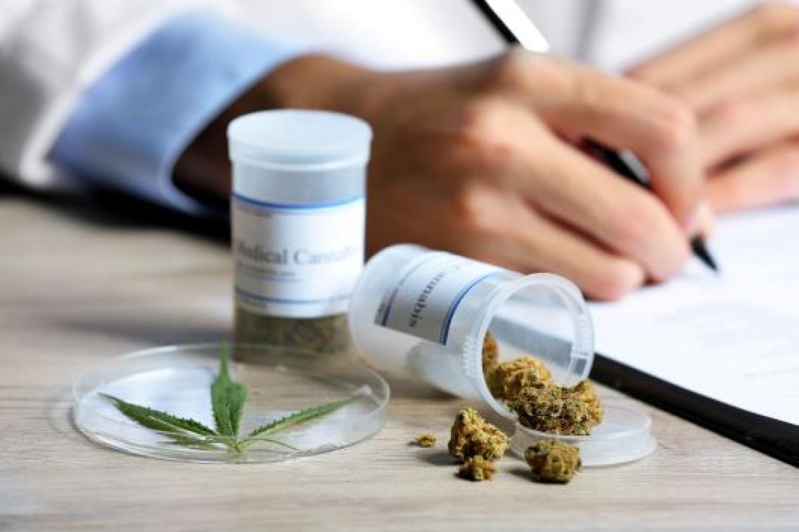 Doctors handwriting a prescription with dried medicinal cannabis.