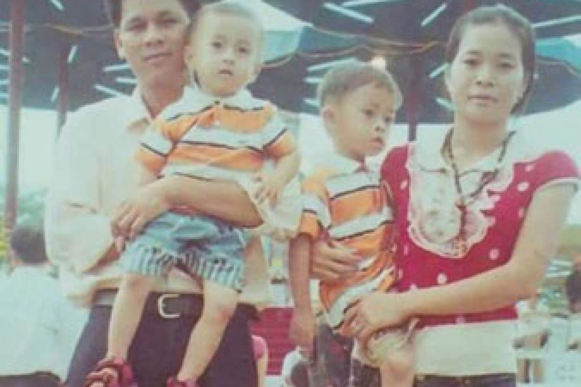 A photo taken in Vietnam of Tiep Tran and Giao Nguyen each holding their children.