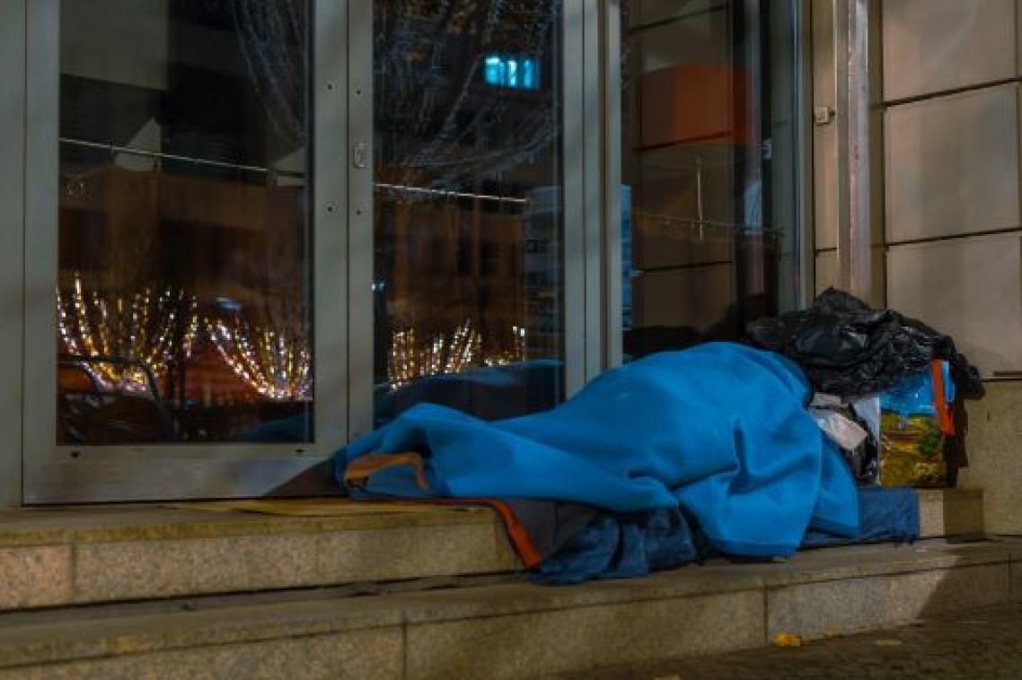 A homeless man asleep on the sidewalk