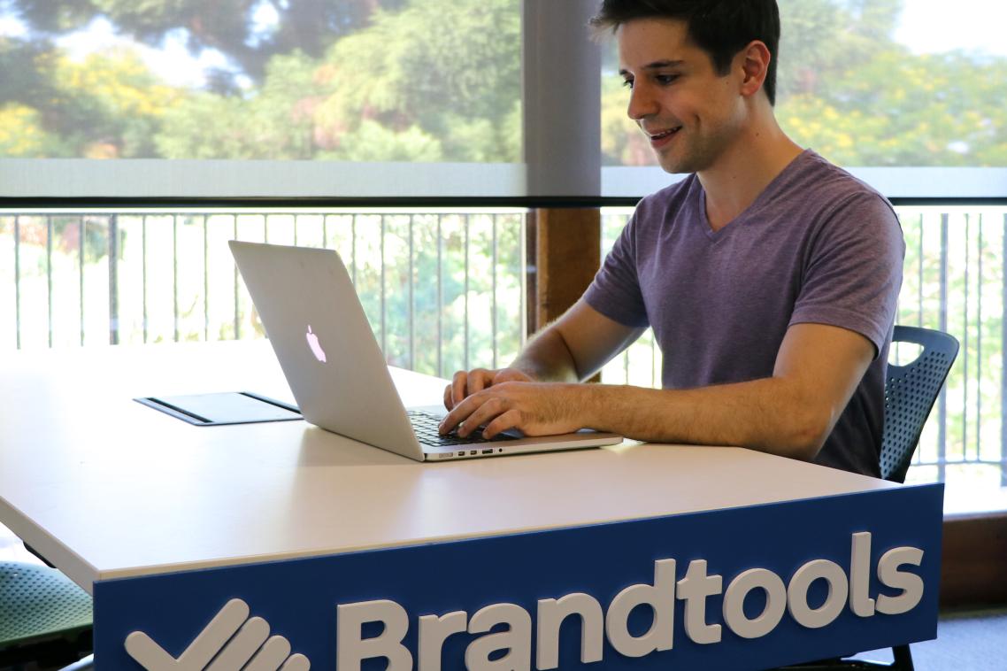 UQ alumnus Nick Georgiou works his laptop at a Brandtools desk