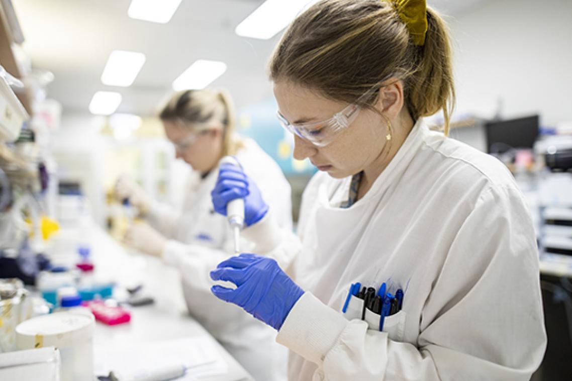 Two female researchers work at the lab bench as part of the vaccine project at UQ