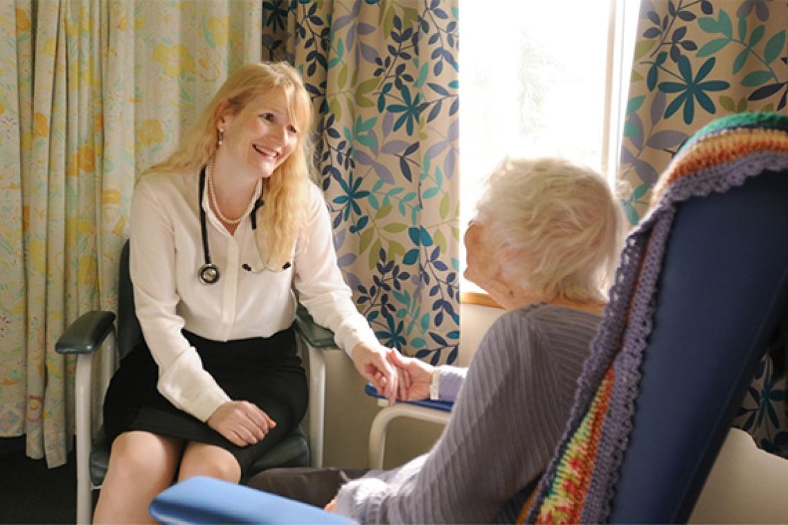 A doctor holding hands with an elderly patient