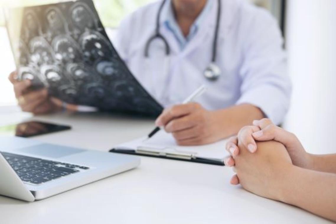 A doctor looks over notes with a pen in hand