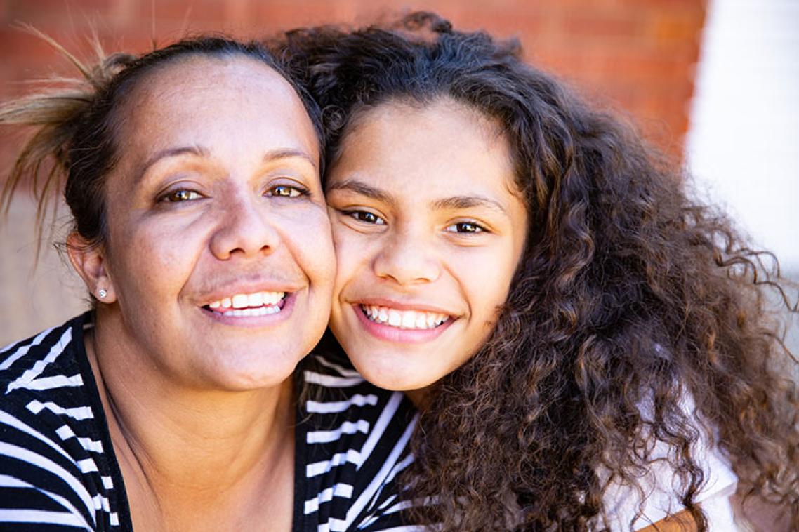Mother and daughter posing smiling together