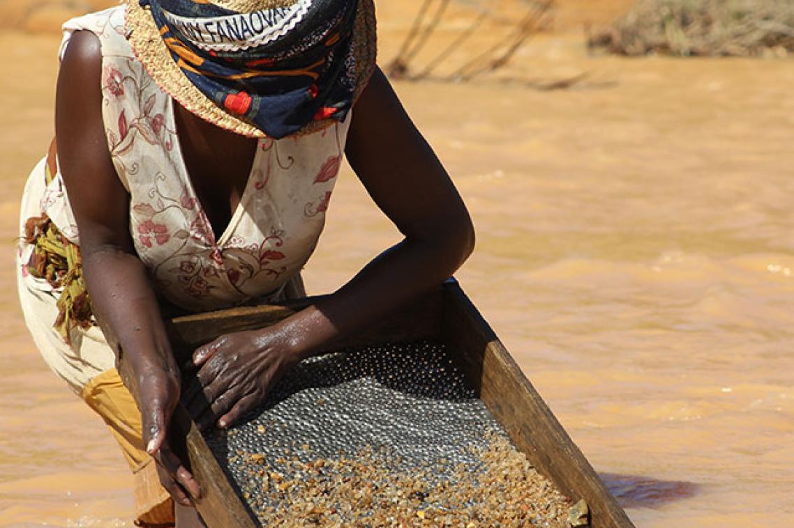 A Malagasy woman sieving for sapphires in a river
