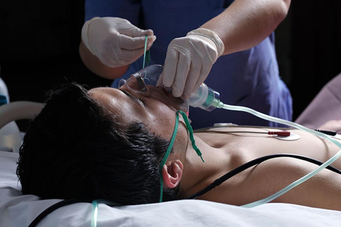 A medical professional treating an unconscious patient