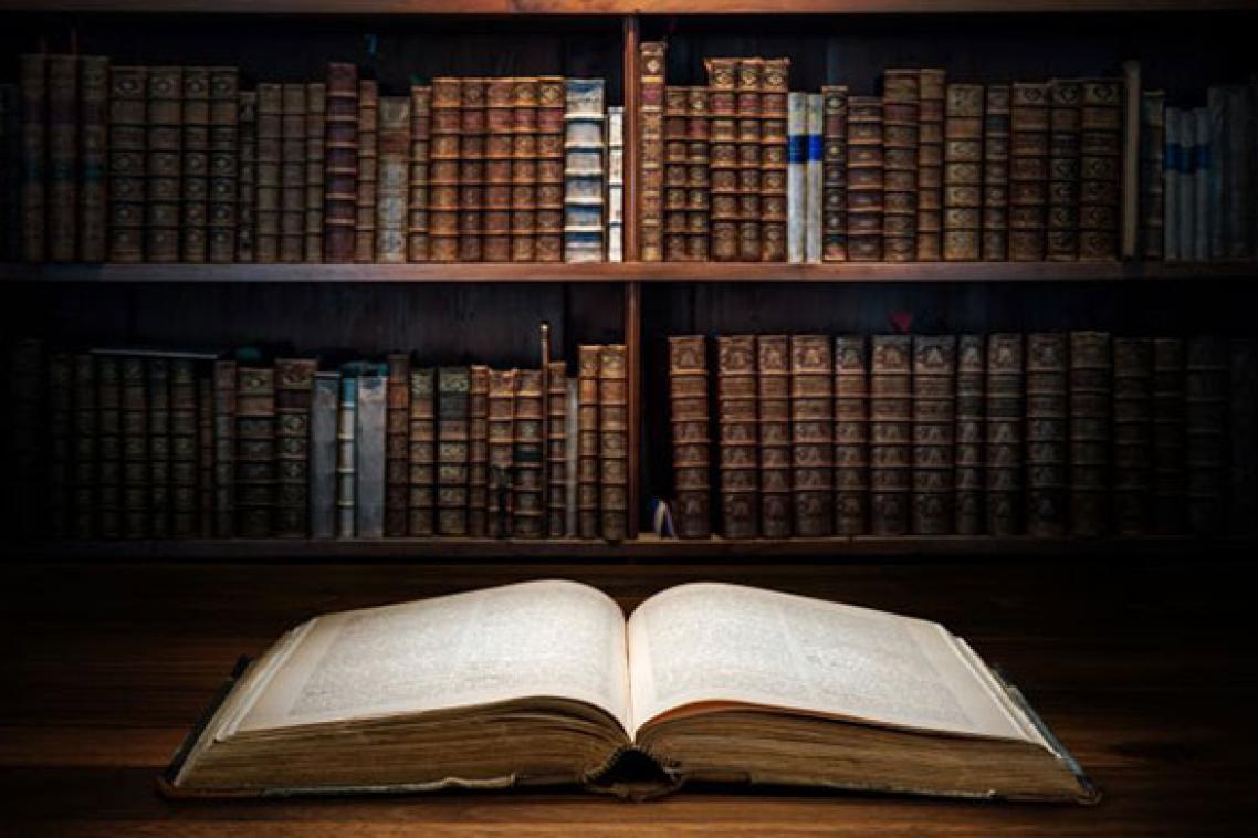 An open book lays on a table in a library