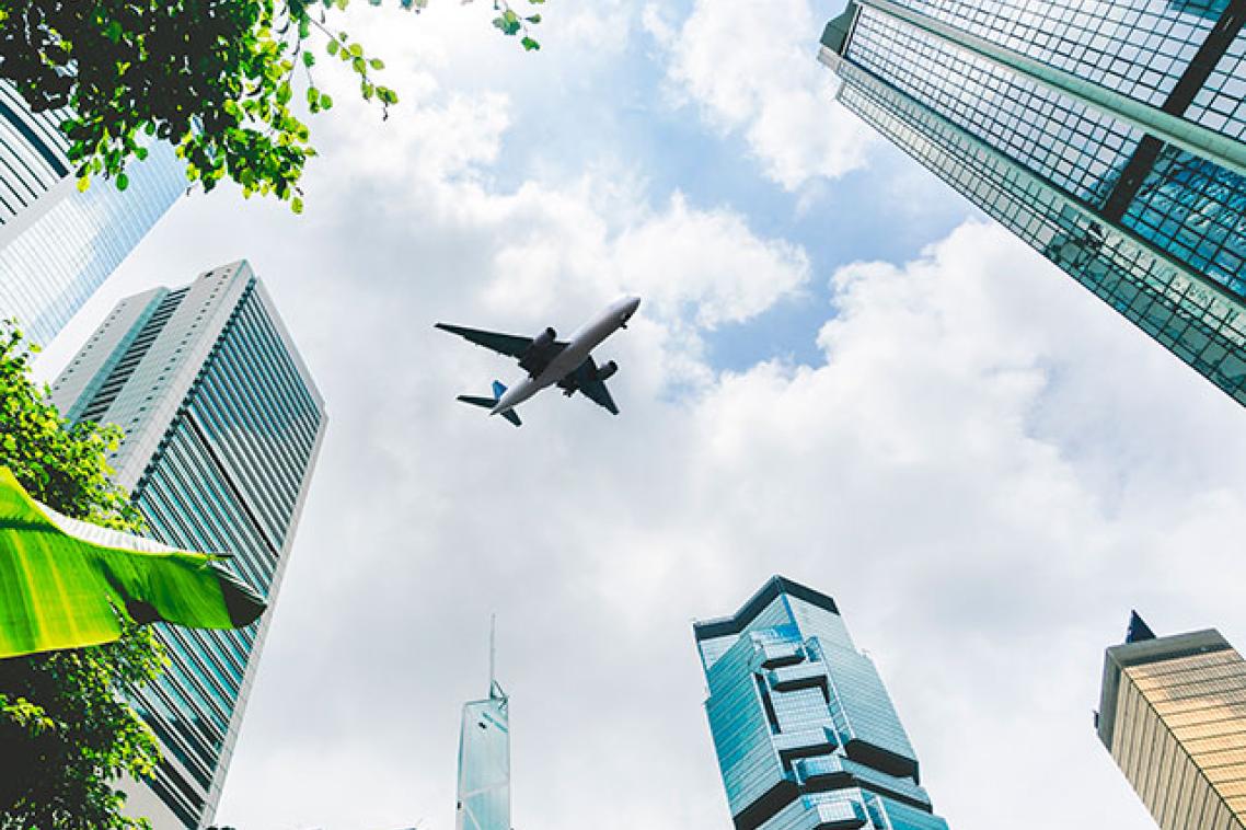 An airplane flying above city buildings