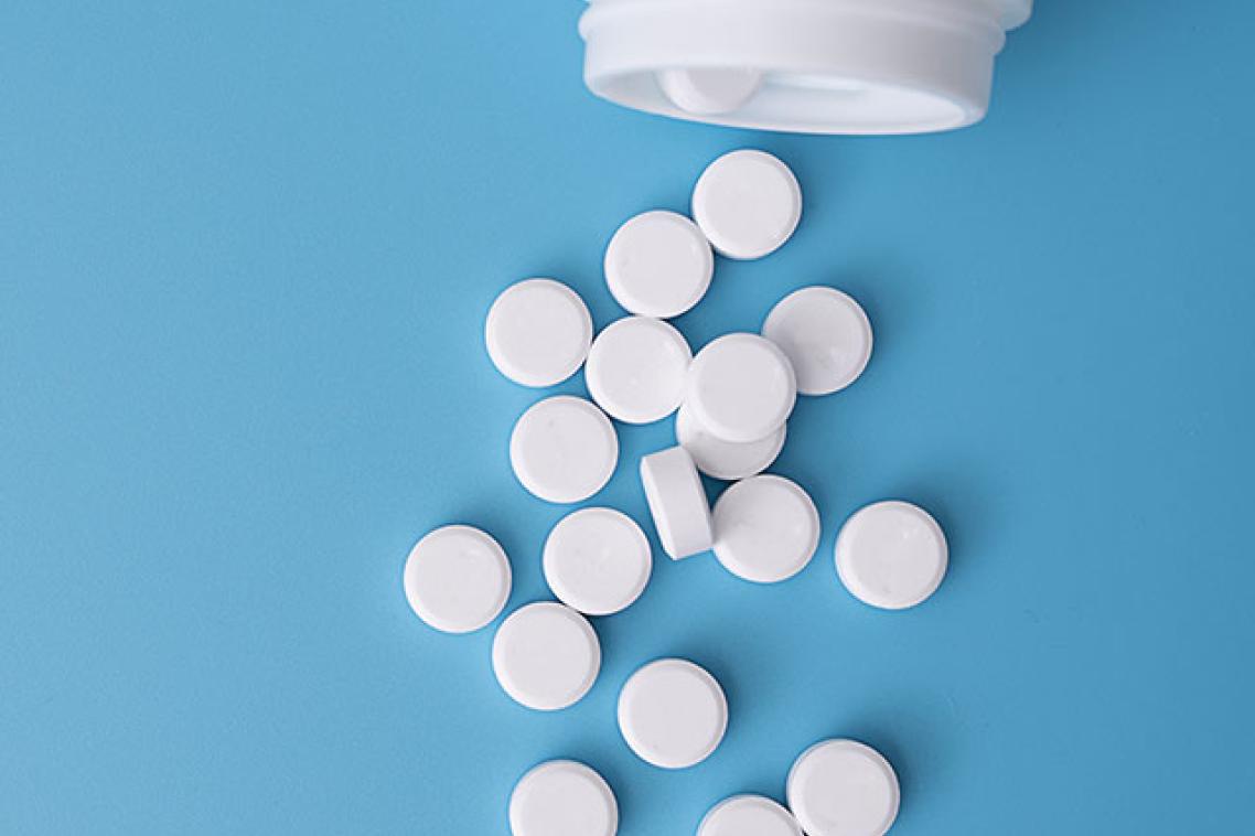 Medical tablets pouring out of a pill bottle