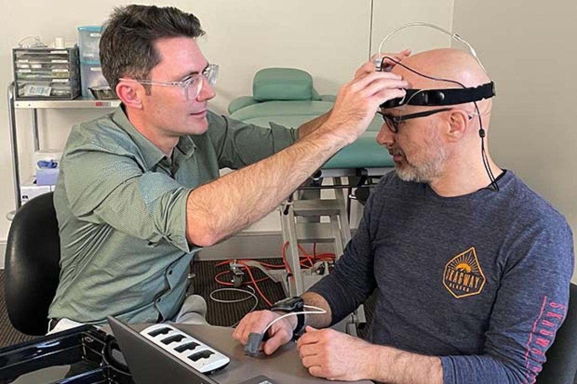 Dr David Klyne fits Wolbert van den Hoorn with a sleep monitoring device on his head