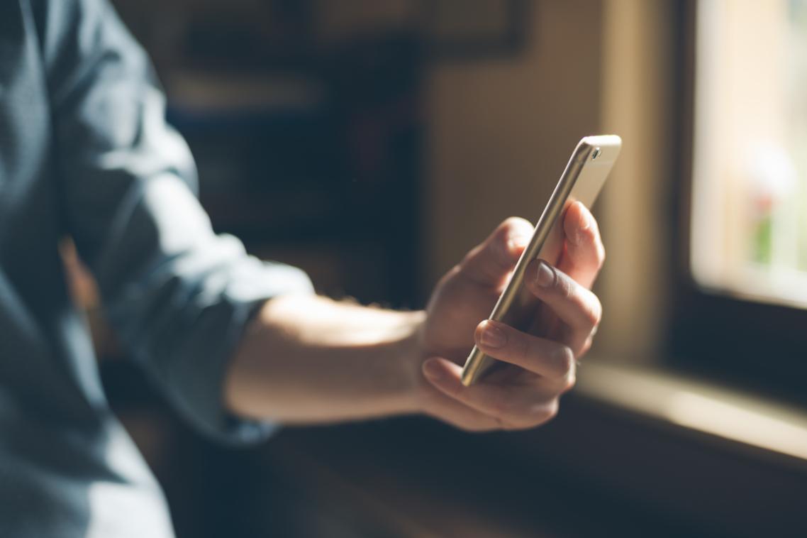 A hand holding a phone, texting.