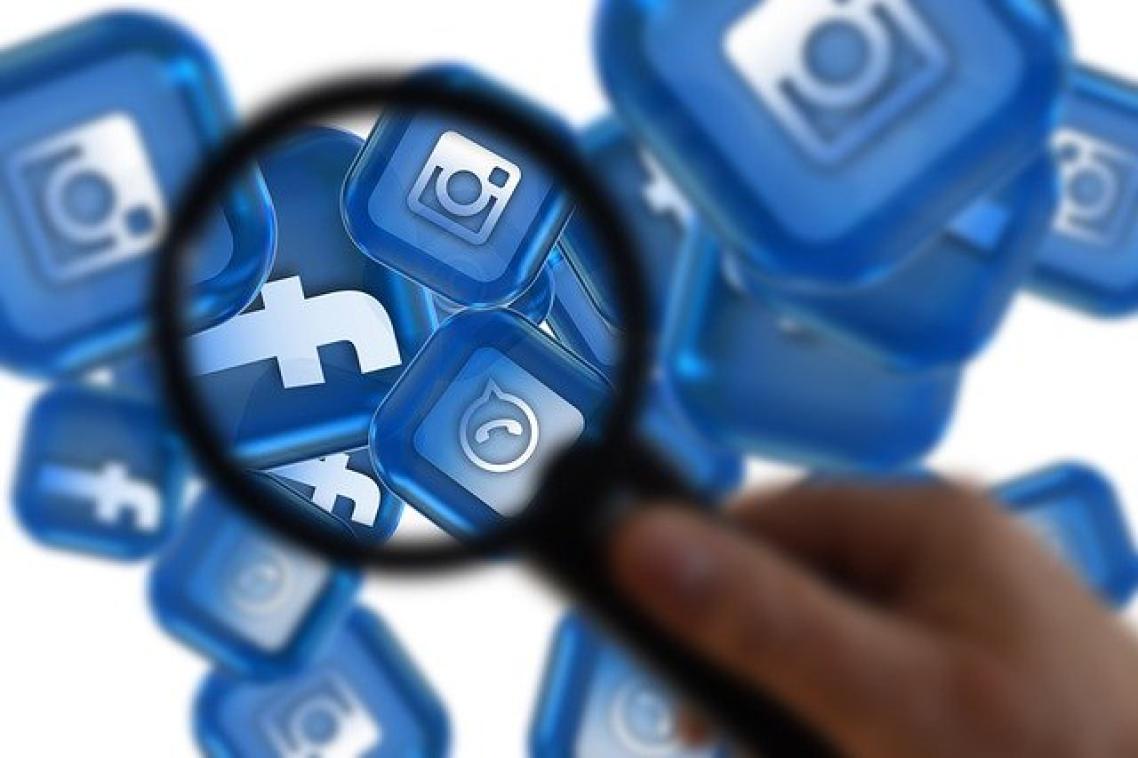 Magnifying glass over social media icons.