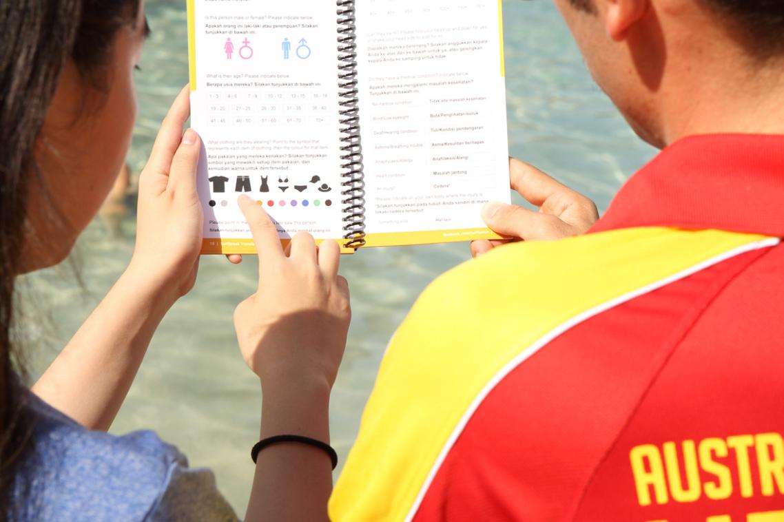 A beachgoer points to the missing person's section