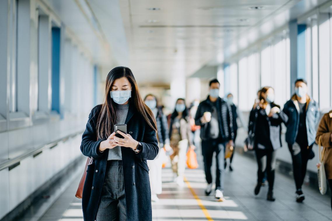 People walk through a hallway with face masks on