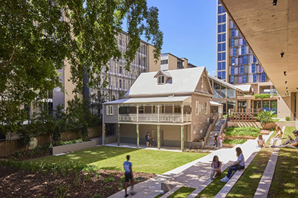 An old Queenslander house overlooking grass and a garden